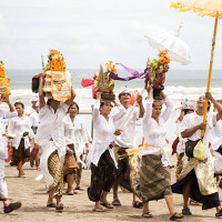 Bali, Indonesia - March 02, 2011: a procession of people сarrying religious offerings on the Seminyak beach for Melasti festival in Bali